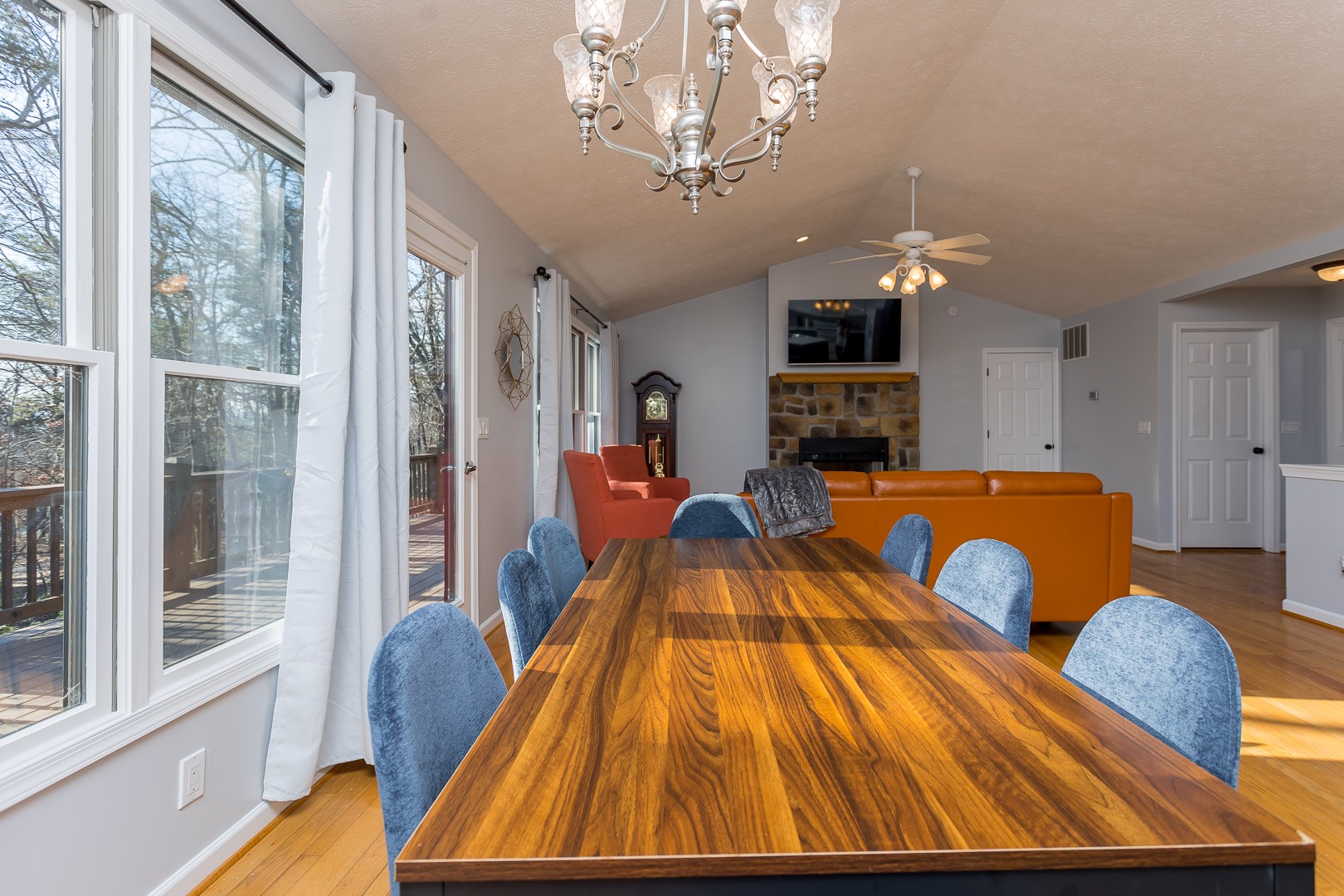 Wooden dining table with blue chairs and large windows