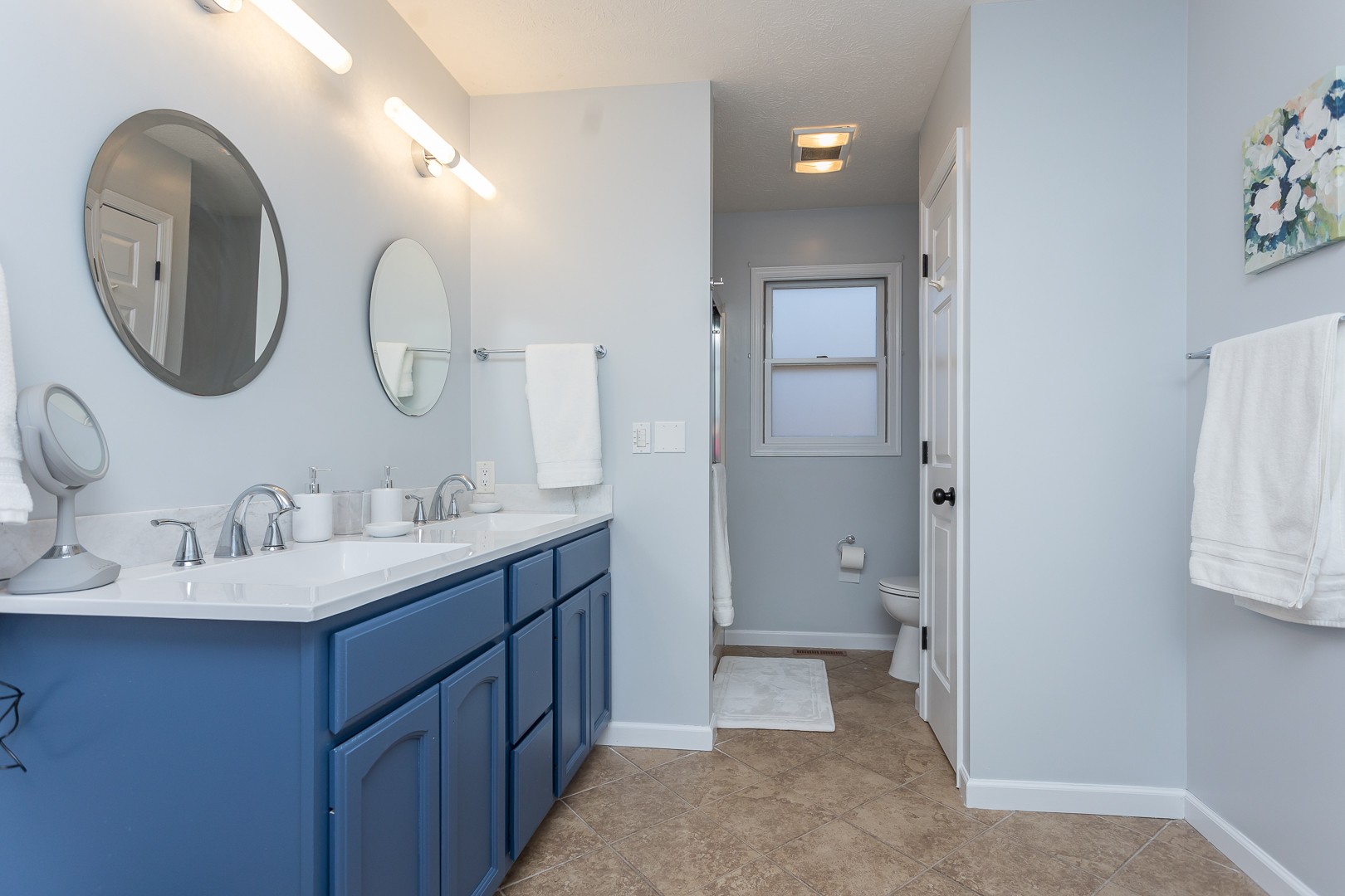 Bathroom with two sinks and blue vanity cabinets
