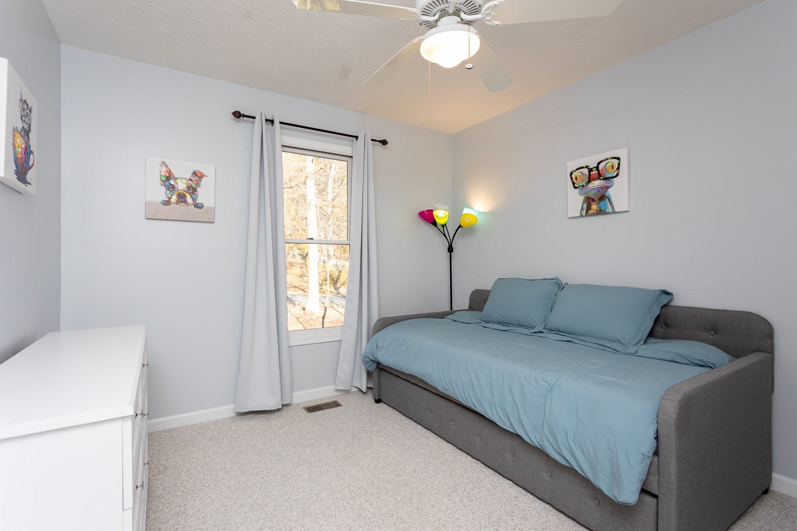 Twin daybed with pull-out trundle and colorful artwork