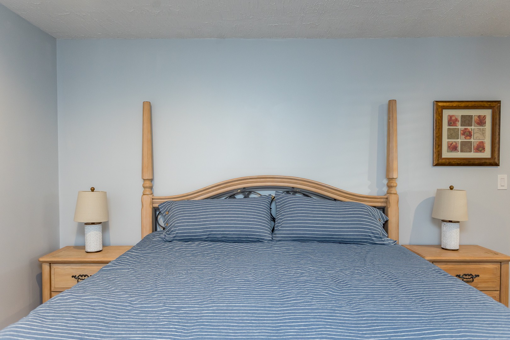 Lower-level king bed with blue striped bedding