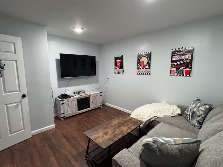Movie room with sofa, television, and movie posters