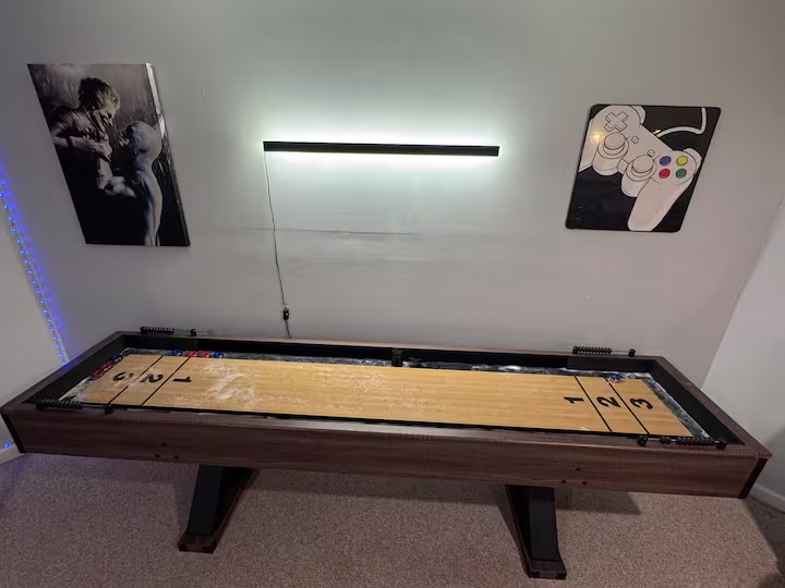 Shuffleboard table beneath a wall light